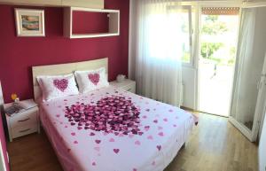 a bedroom with a bed with pink hearts on it at Apartment Nima Orebic in Orebić