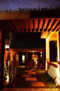 an outdoor patio with a wooden pergola at night at Green 53 Boutique Hotel in Ilhéus