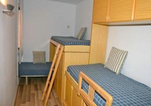 a room with two bunk beds and two chairs at Cantilmar CALA FONT in Salou