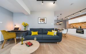 een woonkamer met een blauwe bank en een tafel bij Barbakan Residence Old Town in Krakau