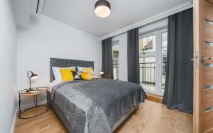 een slaapkamer met een bed en een groot raam bij Barbakan Residence Old Town in Krakau