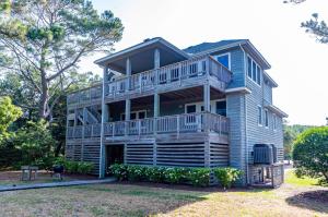 a large house with a large deck on top at Sunset Royale in Duck
