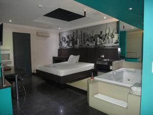 um quarto com uma cama e uma banheira em Impulse Motel em São Bernardo do Campo