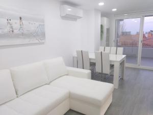 a white living room with a white couch and a table at Luxury CAP SALOU with POOL & BARBECUE & WIFI in Salou