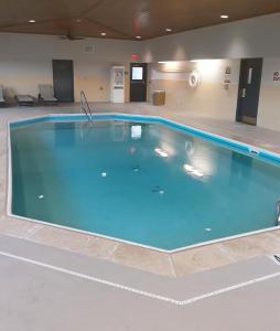 a large swimming pool in a building with blue water at Country Inn & Suites by Radisson, DFW Airport South, TX in Irving