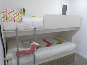 a white bunk bed with a dinosaur toy on it at Luxury CAP SALOU with POOL & BARBECUE & WIFI in Salou +14 photos