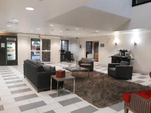 a waiting room with couches and chairs and tables at Country Inn & Suites by Radisson, DFW Airport South, TX in Irving +35 photos