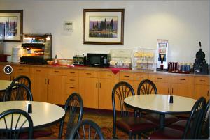 two tables and chairs in a restaurant with a counter at Crystal Inn Hotel & Suites - Great Falls in Great Falls