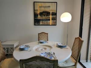 a dining room table and chairs with a white table and a table and chairsuggest at luxueux pied-à-terre avec jardin et garage privés in Dār Şāliḩ Bey