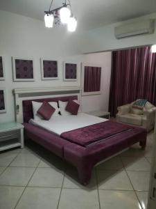 a bedroom with a large bed and a chair at Apartment at Milsa Nasr City, Building No. 35 in Cairo