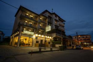 un bâtiment avec des lumières devant lui la nuit dans l'établissement Saffroni Inn, à Paralia Katerinis