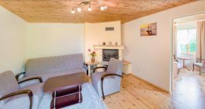 a living room with a table and chairs and a fireplace at The River House in Anykščiai
