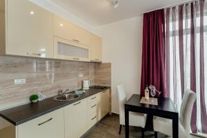 a kitchen with a sink and a table with chairs at Apartments Joy in Herceg-Novi +79 photos
