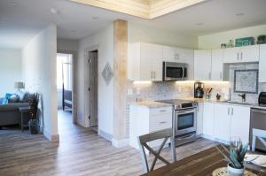 a kitchen with white cabinets and a table and a dining room at Valley View in Lake Cowichan