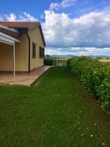 una casa con un prato accanto a un edificio di Il Giardino a Riotorto