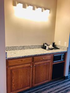 a kitchen with wooden cabinets and a counter top at Country Inn & Suites by Radisson, Nashville Airport East, TN in Nashville