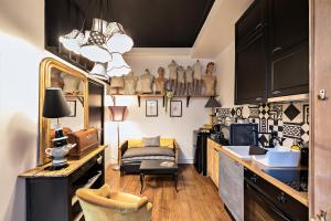 a kitchen with black cabinets and a table with a chair at Les Petites Suites Dieppoises - L'Atelier Couture in Dieppe +43 photos