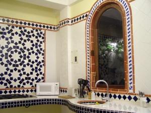 un baño con lavabo y espejo en Posada Colonial Beach Villas, en San Juan