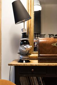 a black and white lamp on a table next to a mirror at Les Petites Suites Dieppoises - L'Atelier Couture in Dieppe