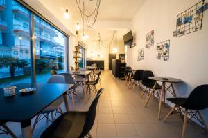a restaurant with tables and chairs and a large window at Saffroni Inn in Paralia Katerinis