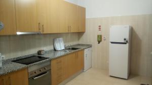 a kitchen with a white refrigerator and a sink at Espreit'ómar - SeaPeek in Setúbal