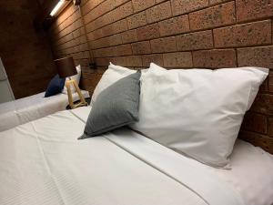 a bed with pillows and pillows on it at Red Steer Hotel Motel Wagga Wagga in Wagga Wagga