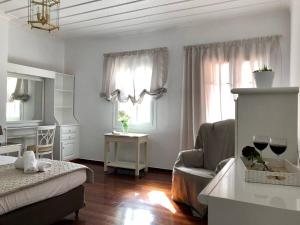 a bedroom with a bed and a chair and windows at Neoclassical mansion with view and garden in Andros