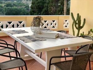 a white table with chairs and a vase on it at Villa Andros Époque in Andros