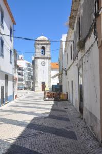 une rue vide dans une ville avec une tour d'horloge dans l'établissement Tic Tac Apartment, à Peniche