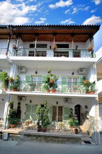 a white building with potted plants on the balconies at Aiolos House in Skiathos