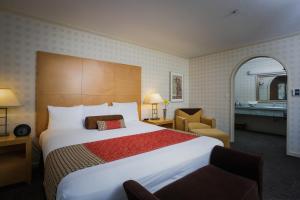 a hotel room with a large bed and a chair at Menlo Park Inn in Menlo Park