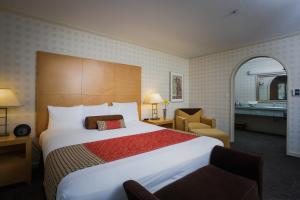 una habitación de hotel con una cama grande y una silla en Menlo Park Inn, en Menlo Park