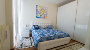 a bedroom with a bed with a blue comforter at Casa Corallo Vicino alle Spiagge in Sanremo