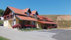 a building with red roofs and flowers in a parking lot at Apartments Pavlić in Rakovica