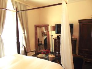 1 dormitorio con cama y espejo grande en The Rendell Shea Manor en San Juan de Terranova