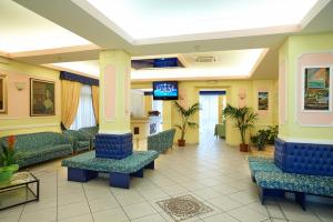 a hospital waiting room with couches and a tv at Hotel Cavallotti & Giotto in Montecatini Terme