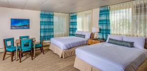 a hotel room with two beds and a table and chairs at Bridgewater Hotel, Trademark Collection by Wyndham in Fairbanks