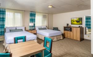 a hotel room with two beds and a table at Bridgewater Hotel, Trademark Collection by Wyndham in Fairbanks