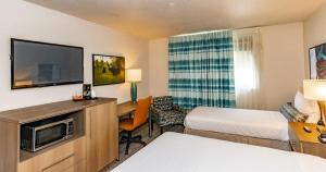a hotel room with a bed and a tv at Bridgewater Hotel, Trademark Collection by Wyndham in Fairbanks