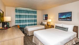 a hotel room with two beds and a desk at Bridgewater Hotel, Trademark Collection by Wyndham in Fairbanks