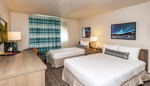 a hotel room with two beds and a desk at Bridgewater Hotel, Trademark Collection by Wyndham in Fairbanks