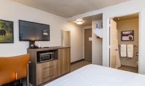 a hotel room with a bed and a flat screen tv at Bridgewater Hotel, Trademark Collection by Wyndham in Fairbanks