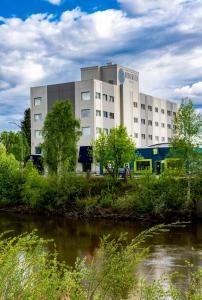 a building with a river in front of it at Bridgewater Hotel, Trademark Collection by Wyndham in Fairbanks