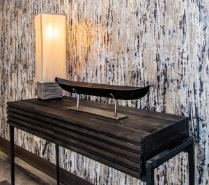 a lamp on a wooden table in front of a wall at Bridgewater Hotel, Trademark Collection by Wyndham in Fairbanks