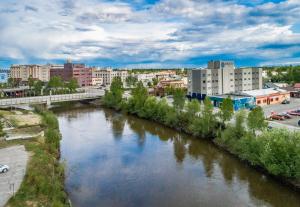 a river in a city with buildings and a bridge at Bridgewater Hotel, Trademark Collection by Wyndham in Fairbanks