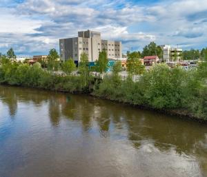 a river with buildings in the background next to a city at Bridgewater Hotel, Trademark Collection by Wyndham in Fairbanks