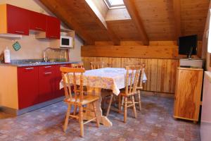 a kitchen with a table with chairs and a sink at Chalet Presanella in Temù