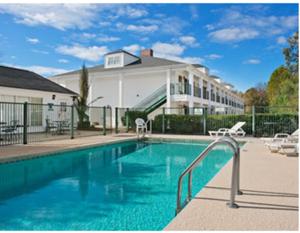 a swimming pool in front of a house at Baymont by Wyndham Roanoke Rapids in Roanoke Rapids