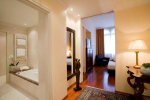 a hotel room with a tub and a bedroom at Astoria Hotel Italia in Udine