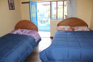 dwa łóżka siedzące obok siebie w pokoju w obiekcie Las Portadas w mieście Ollantaytambo
